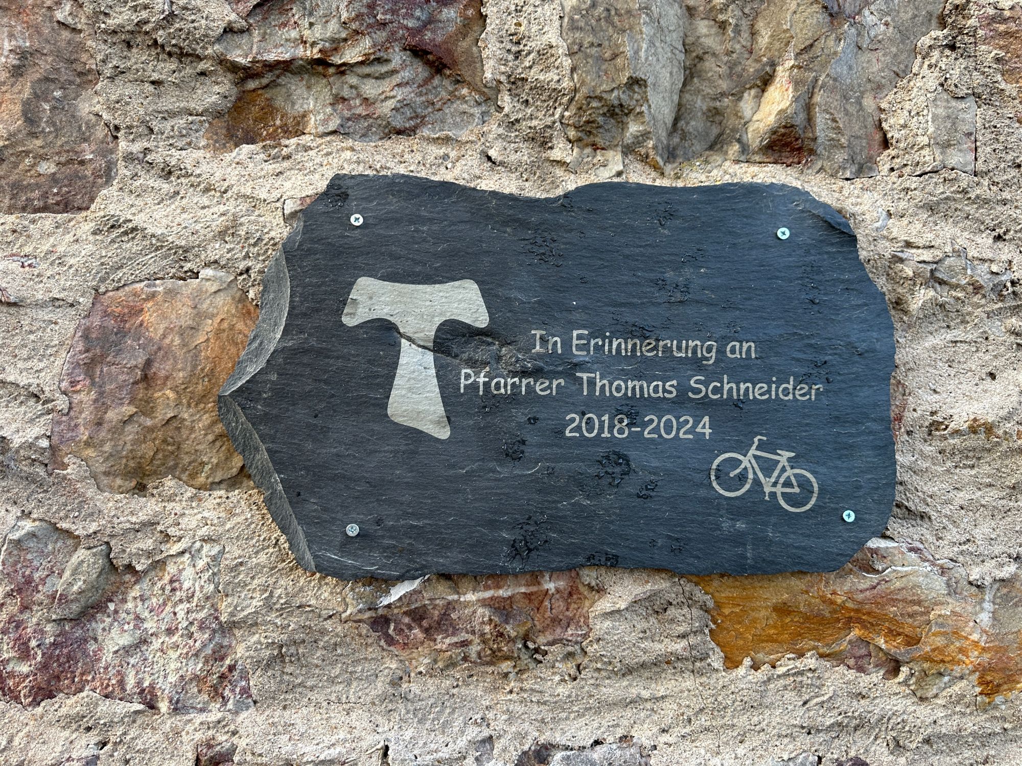 Eine Gedenktafel erinnert an Pfarrer Thomas Schneider. Die Tafel wurde von Aaron Kleid gestaltet, dem Patenkind von Thomas Schneider
