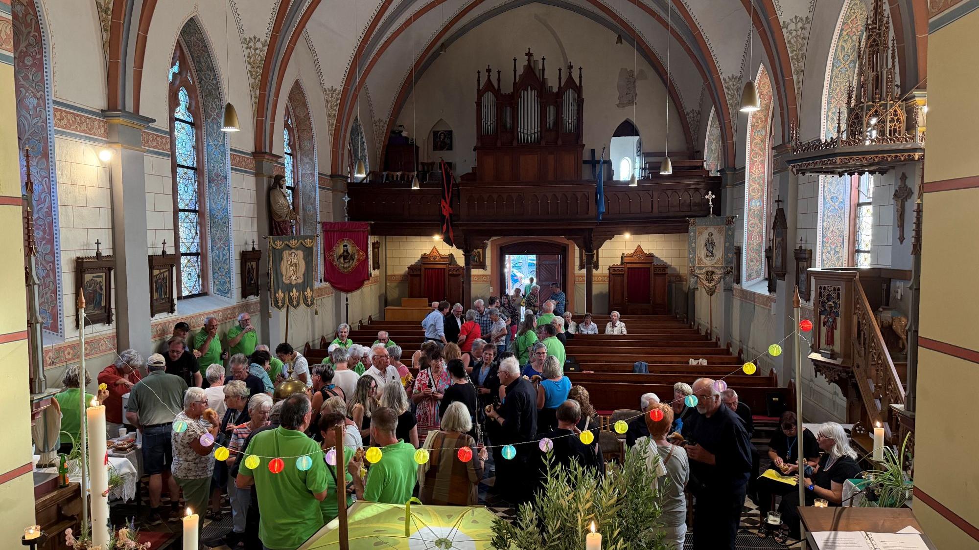 Kirchenbesucher beim Umtrunk nach dem Abendlob