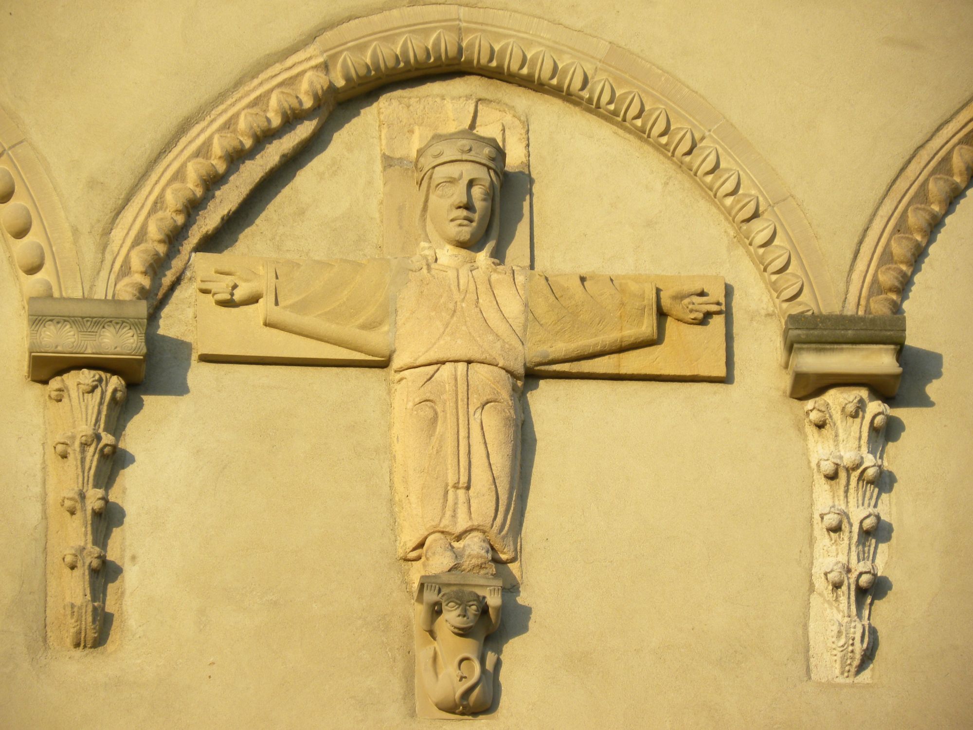 Am Westwerk der romanischen Stiftskirche in Ravengiersburg befindet sich ein bekleideter „volto santo“ in der Tradition des „wahren Abbild Christi“ im Dom von Lucca aus der Zeit um 800. Das einzige Abbild in Stein, außen an einer Kirche. Christus als König, in einem gegürteten Königsgewand, lebend vor einem Kreuz stehend, gekrönt, gestützt von einem Hund, dem Symbol der Treue, segnet er mit beiden Händen! Diese Arbeit geht in die Frühzeit des Stiftes zurück und könnte noch aus der Zeit der Burgkapelle stammen. Die Christusdarstellung gehört zu den seltensten und kostbarsten im Rheinland, vielleicht darüber hinaus