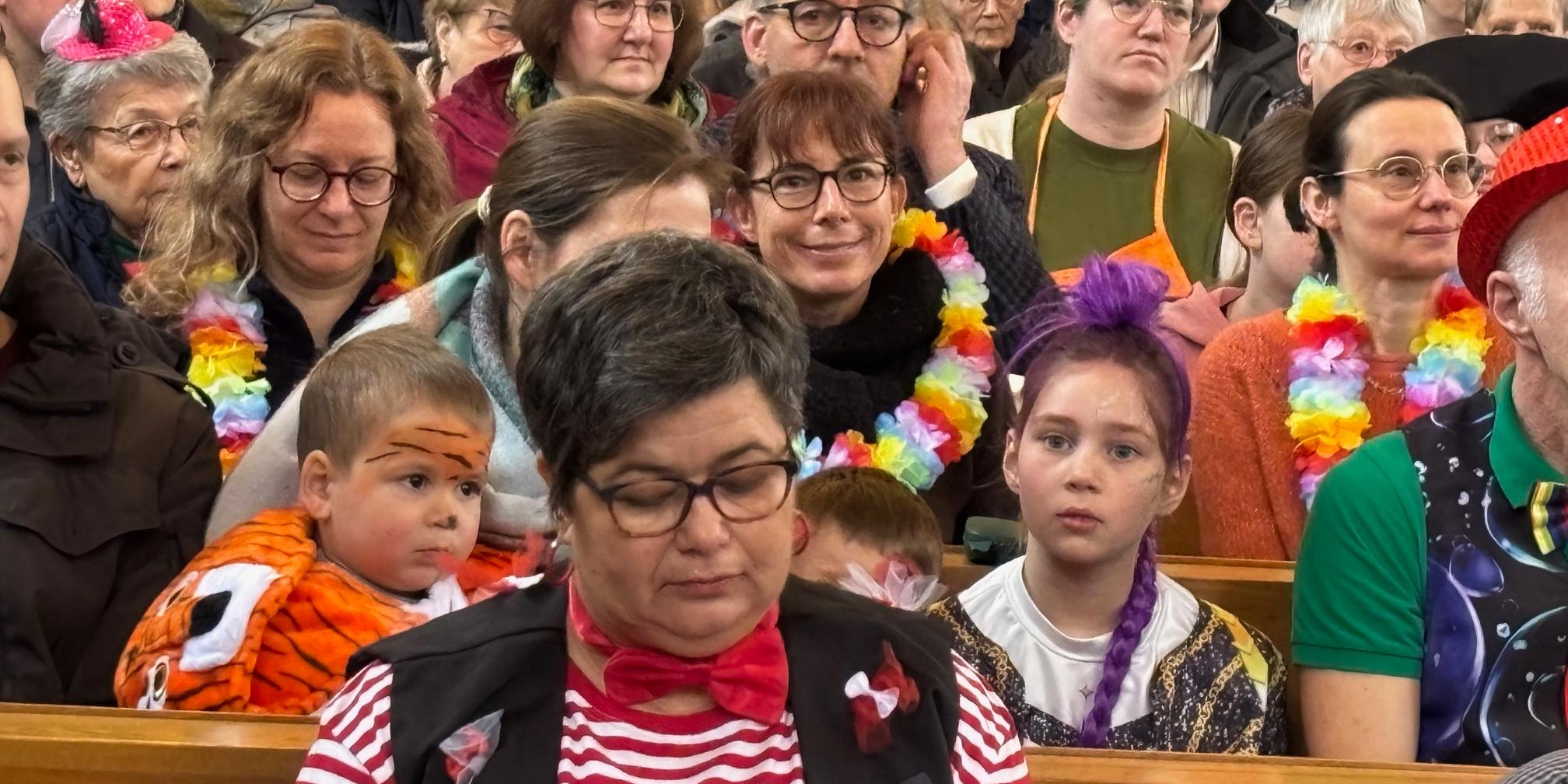 voll besetzt und bunt kostümiert feiert viele Gläubige beider Konfessionen den ökumenischen Karnevalsgottesdienst in Biebern mit
