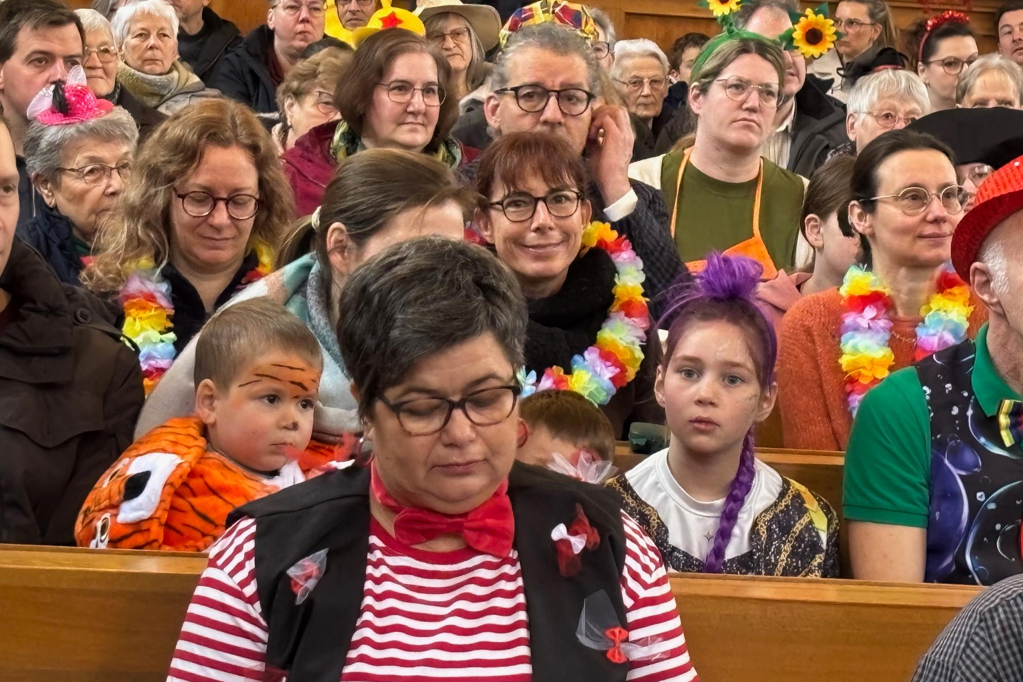 voll besetzt und bunt kostümiert feiert viele Gläubige beider Konfessionen den ökumenischen Karnevalsgottesdienst in Biebern mit